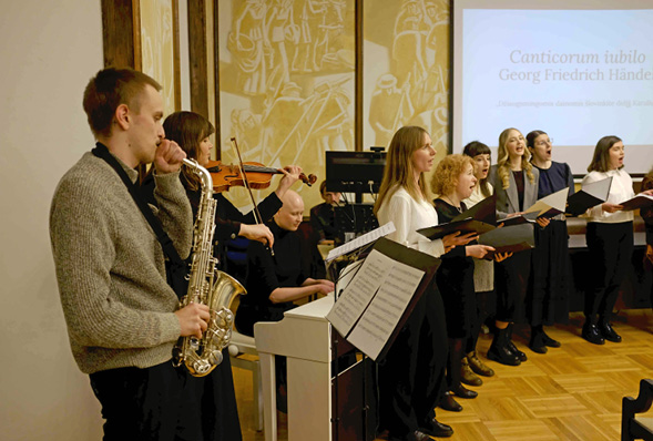 A man playing a saxophone in front of a group of people.
Description generated by AI