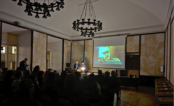 A large group of people are sitting in a dark room, watching a movie on a large screen.
Description generated by AI