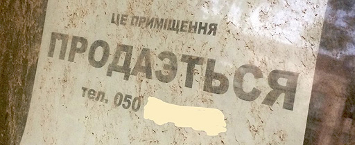 Фото 6. На грязном окне частного дома на листе бумаги крупными буквами напечатан текст о продажи помещения на украинском: «ЦЕ ПРИМІЩЕННЯ ПРОДАЄТЬСЯ». В слове «ПРОДАЄТЬСЯ» используется русская буква «Э» вместо украинской «Є», что является ошибкой. Ниже используется сокращение «тел.» с указанием кода украинского оператора связи «050» (последующие цифры скрыты автором этой статьи для сохранения конфиденциальности).